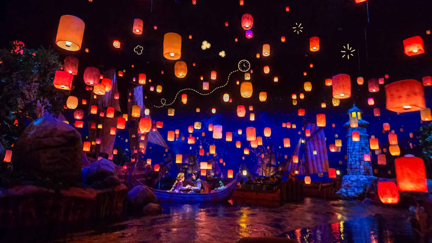Faroles brillantes llenan la oscuridad sobre Rapunzel’s Lantern Festival, acompañados por pequeños dibujos de una fila, un reloj, destellos y popcorn.